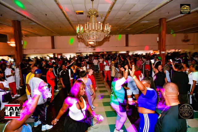A packed dance floor under the chandelier, hands in the air