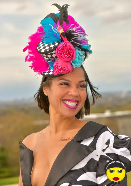 Guest in a feathered pink and turquoise headpiece